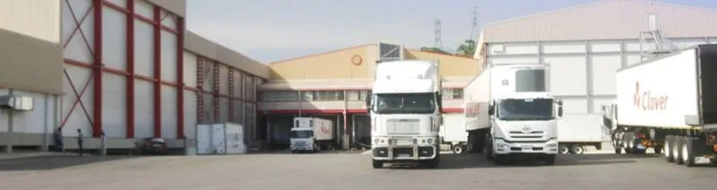 Refrigerated trucks at the loading bays of a Clover Dairy building