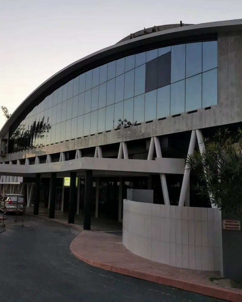 The curved glass front and entrance canopy of the Olive Convention Centre in Durban at dusk