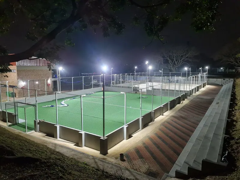 The Pitlochry multi-sport court at night, floodlit, with stepped seating and brick paving down one side