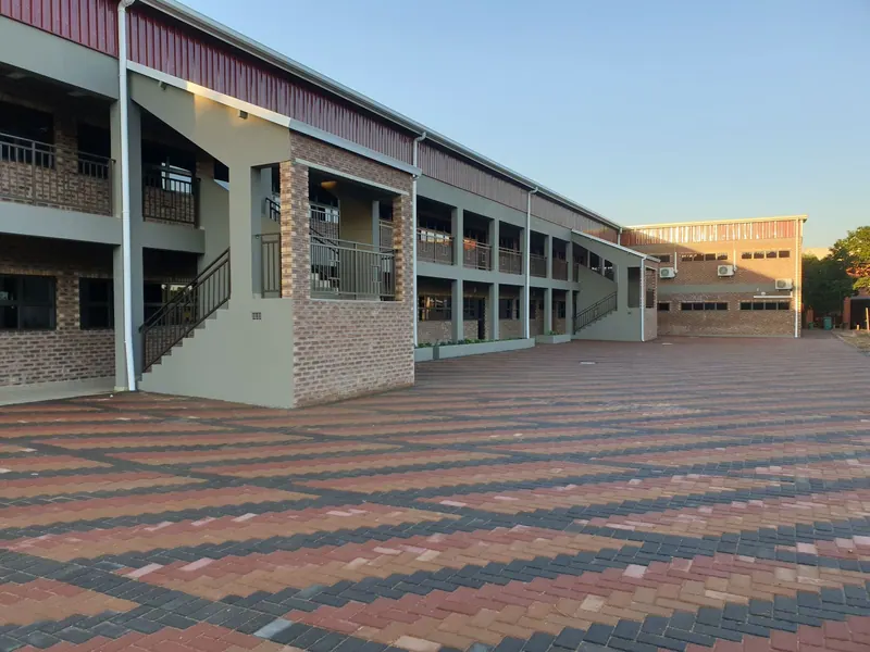 A two-storey face-brick classroom block at Pitlochry Primary School with a new paved forecourt in late sun