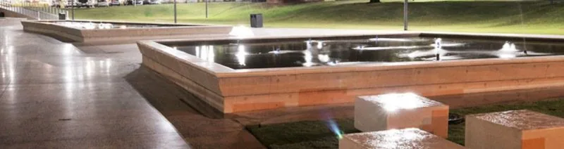 A lit water feature and paved square along the upgraded Walter Gilbert Road